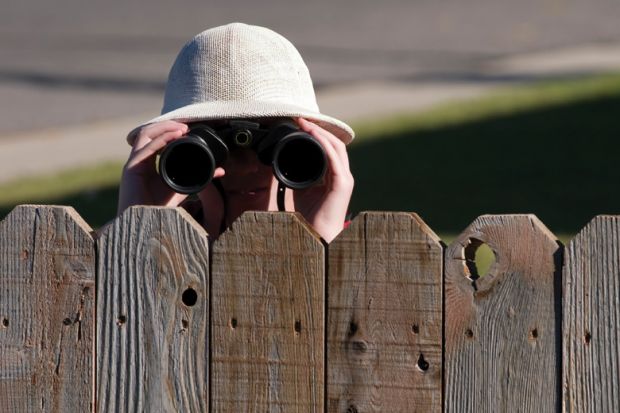 person-looking-over-fence-with-binoculars.jpg
