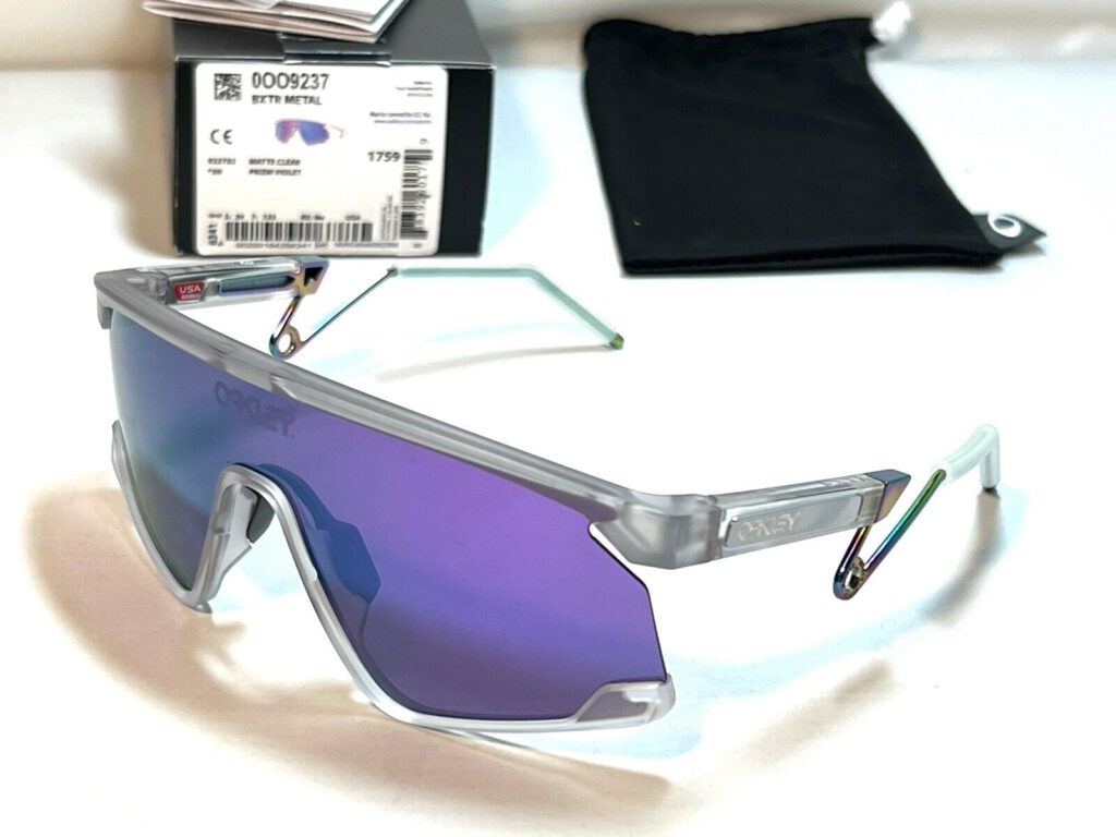 Oakley BXTR Metal sunglasses with a clear frame and Prizm Violet lenses with the box and microfiber bag